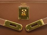 a close up of a brown leather handbag with gold hardware