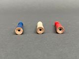 three different colored thread spools sitting on top of a table