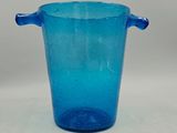 un vase en verre bleu muni d'anses, posé sur une table