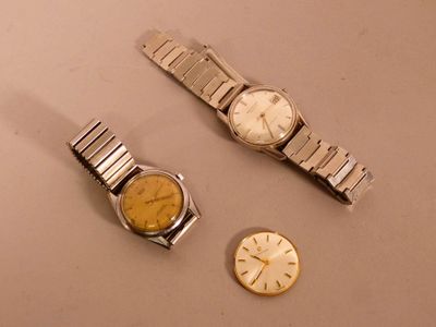 two watches and a watch sitting on a table next to each other