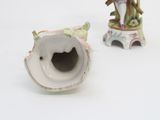 pair of porcelain figurines of a man and a woman on a tree stump