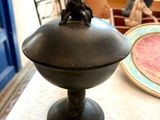 une petite statue représentant un singe assis sur un bol