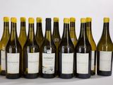 six bouteilles de vin sont alignées sur une table