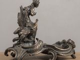 a silver figurine of a woman sitting on top of a table