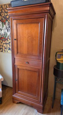 a tall wooden cabinet in the corner of a living room