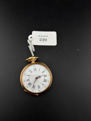 a close up of a gold pocket watch with a tag on it