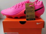 La chaussure de foot Nike Vapor rose est posée sur une boîte orange
