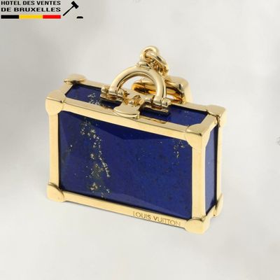 une photo d'une valise bleue avec une poignée dorée
