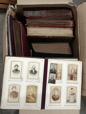 a box full of old photos of men and women