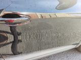 a reflection of a car ' s door handle on the side of the car