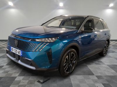 un 4x4 bleu garé sur un sol en damier dans un garage
