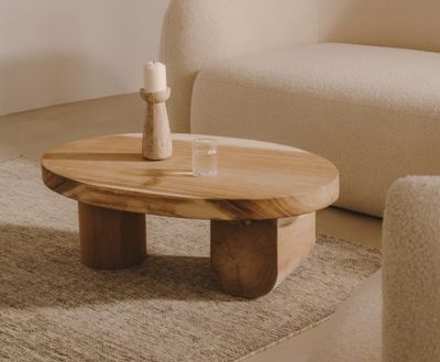 une table en bois sur laquelle est posée une bougie, dans un salon