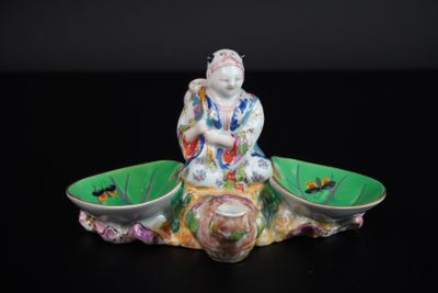 une figurine représentant une personne assise sur un bol