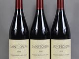 three bottles of wine sit on a table in front of a gray background