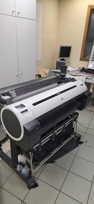 une grande imprimante posée sur un support dans une pièce