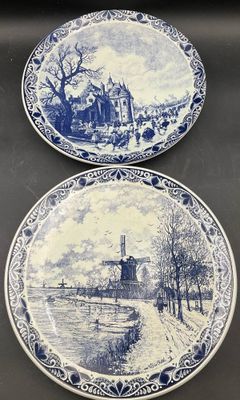 deux assiettes bleues et blanches sur lesquelles est représenté un village