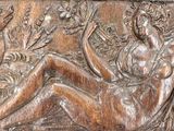 relief of a woman sitting on a bench in a garden of flowers