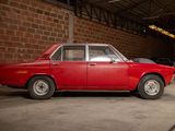 a red car parked in a garage next to a brick wall