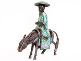 a figurine of a man riding a horse with a hat on