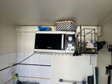 a microwave on top of a shelf above a sink