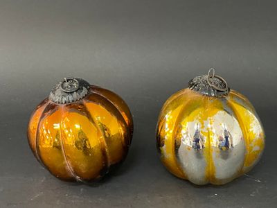 deux citrouilles en verre posées l'une à côté de l'autre sur une table