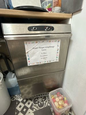 a dishwasher with a sign on it in a kitchen