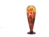 un vase en verre sur lequel sont peintes des fleurs sur un fond blanc