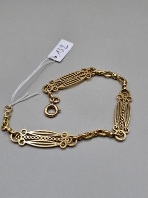 Gros plan sur un bracelet en or portant une étiquette