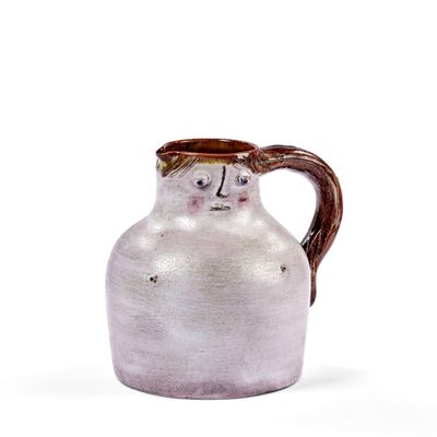 un vase blanc avec une anse marron sur fond blanc