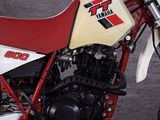 a red and white dirt bike parked in a parking lot