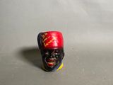 une figurine représentant un homme coiffé d'un chapeau rouge