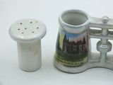 a small cup and a salt shaker sitting on a table