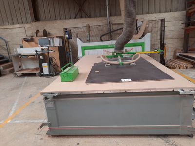 a machine that is cutting a piece of wood on a table