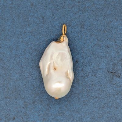 un gros plan d'un pendentif en perle blanche sur un fond bleu