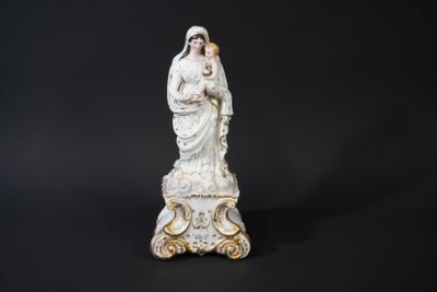 une statue blanche représentant une femme tenant un enfant dans ses bras, sur fond noir
