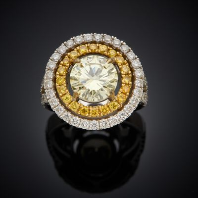 a yellow and white diamond ring on a black surface