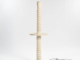 a white floor lamp with a wooden base and a black cord