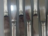 a lot of silver spoons and knives on the table