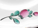 a white plate with a pink flower painted on it