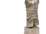 une sculpture en argent représentant un torse posé sur un socle