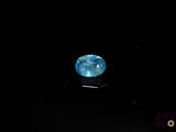 a close up of a blue diamond on a black surface