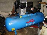 a blue air compressor sitting on top of a blue tank