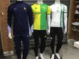 three mannequins wearing different colored soccer uniforms in a store