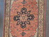 a rug on the floor with a chair in the background