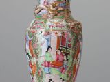 a vase that is sitting on a table with a lid