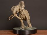 statue of an elephant with tusks on a wooden table
