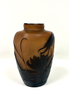 un vase marron orné d'un oiseau sur un fond blanc