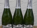 trois bouteilles de vin posées sur une table en bois
