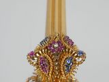 a gold vase with a bunch of colorful stones on top of it