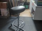 a black stool sitting in the middle of a room
